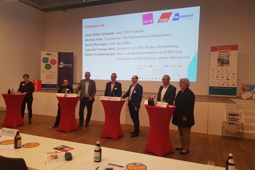 Redner einer Podiumsdiskussion auf der Bühne