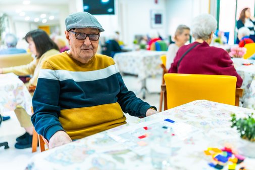 &Auml;lterer Mann genie&szlig;t Freizeitaktivit&auml;ten im Pflegeheim 