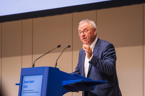 VdK-Gesundheitstag 2025 Hans-Josef Hotz Hans-Josef Hotz spricht energisch ins Mikrofon, während er auf der Bühne am Rednerpult steht