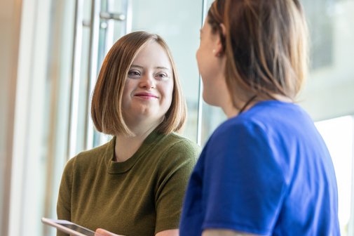 Junge erwachsene Frau mit Down-Syndrom im Gespr&auml;ch mit ihrer &Auml;rztin.