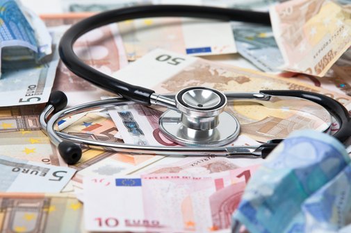 Stethoskop liegt auf zahlreichen Geldscheinen der Euro-W&auml;hrung