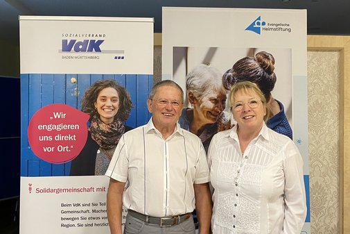 Zwei Personen vor Rollups blicken in die Kamera