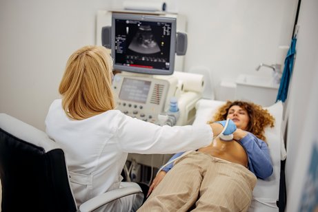 Ärztin untersucht die Gebärmutter ihrer Pantientin mit einem Ultraschallscanner