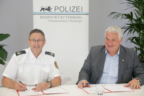 Sozialverband VdK schließt mit Polizeipräsident Udo Vogel Kooperationsvereinbarung zur Warnung von Senioren Polizeipräsident Udo Vogel links im Bild und Jürgen Neumeister, rechts daneben sitzend, am Tisch, sie unterschreiben die Kooperationsvereinbarung.