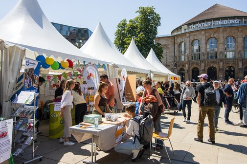 Infozelte beim Aktionstag - die Sonne scheint, zahlreiche Besucher laufen an den Zelten vorbei und sind in Gespräche verwickelt.