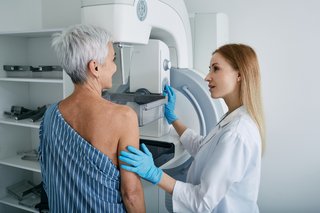 Ältere Frau mit Mammographie-Scan im Krankenhaus mit Medizintechniker