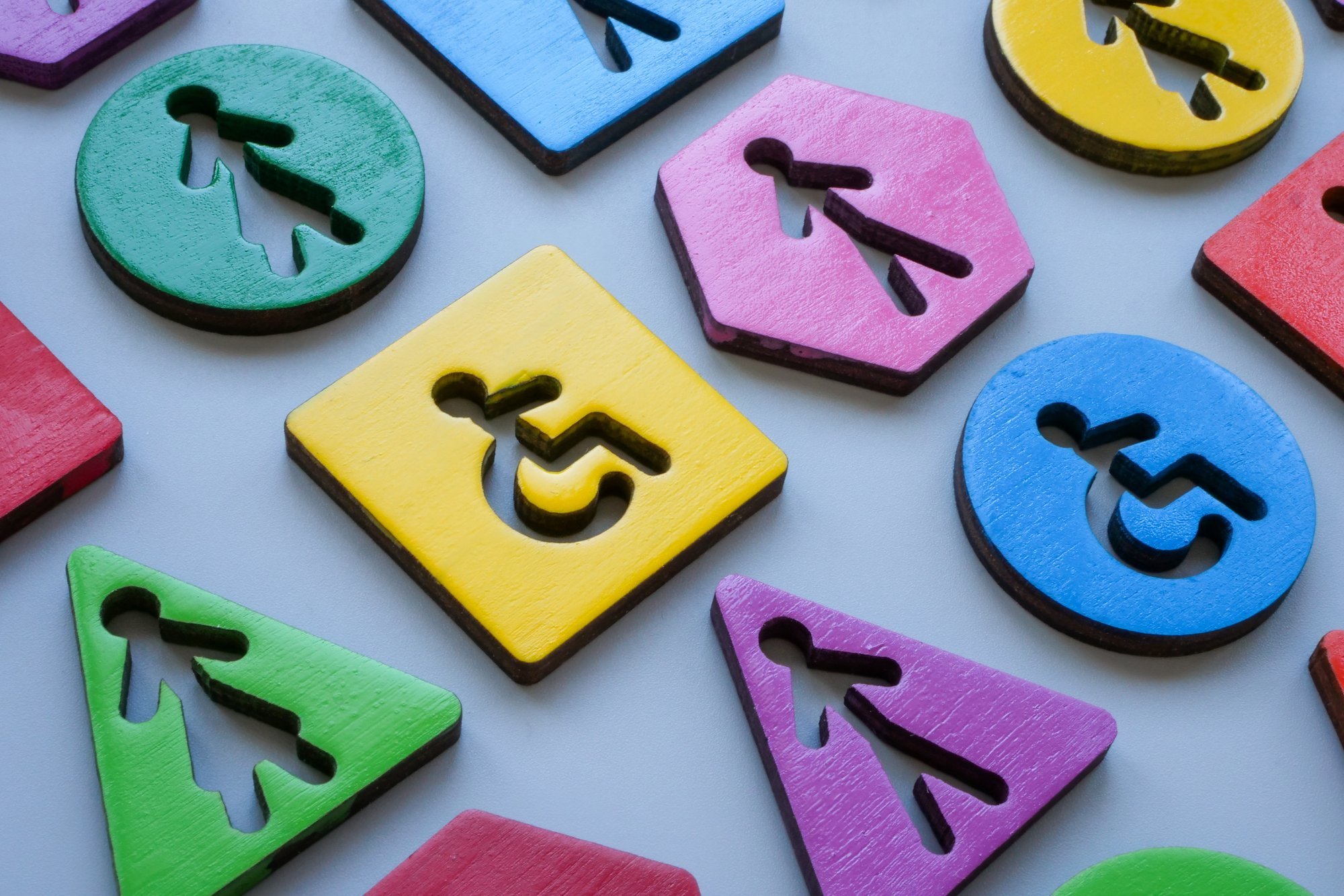 Unterschiedliche bunte Figuren mit Icons von Menschen, stehend oder im Rollstuhl.