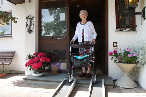 Pflege macht arm - Frau Knörle mit Rollator an ihrer Haustür.