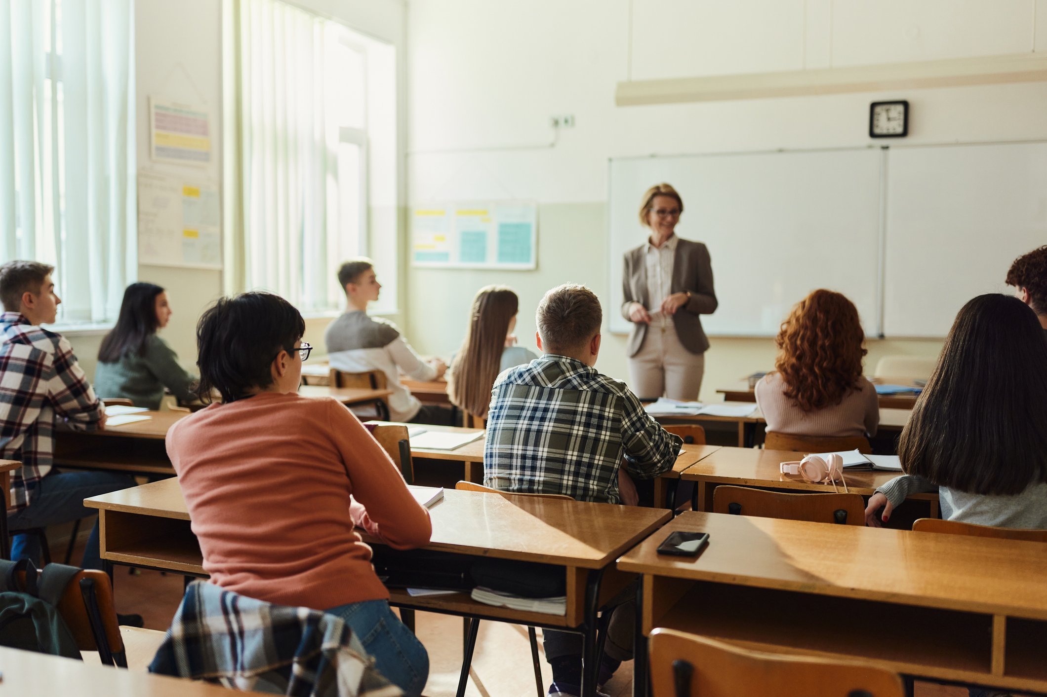 R&uuml;ckansicht von Gymnasiasten, die ihrem Unterricht in einer Klasse zuh&ouml;ren. 