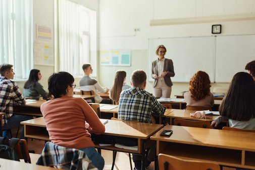 R&uuml;ckansicht von Gymnasiasten, die ihrem Unterricht in einer Klasse zuh&ouml;ren. 