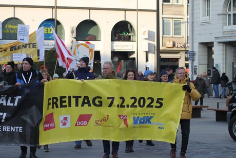Demozug: Menschen laufen mit einem großen Transparent durch die Straßen von Karlsruhe.