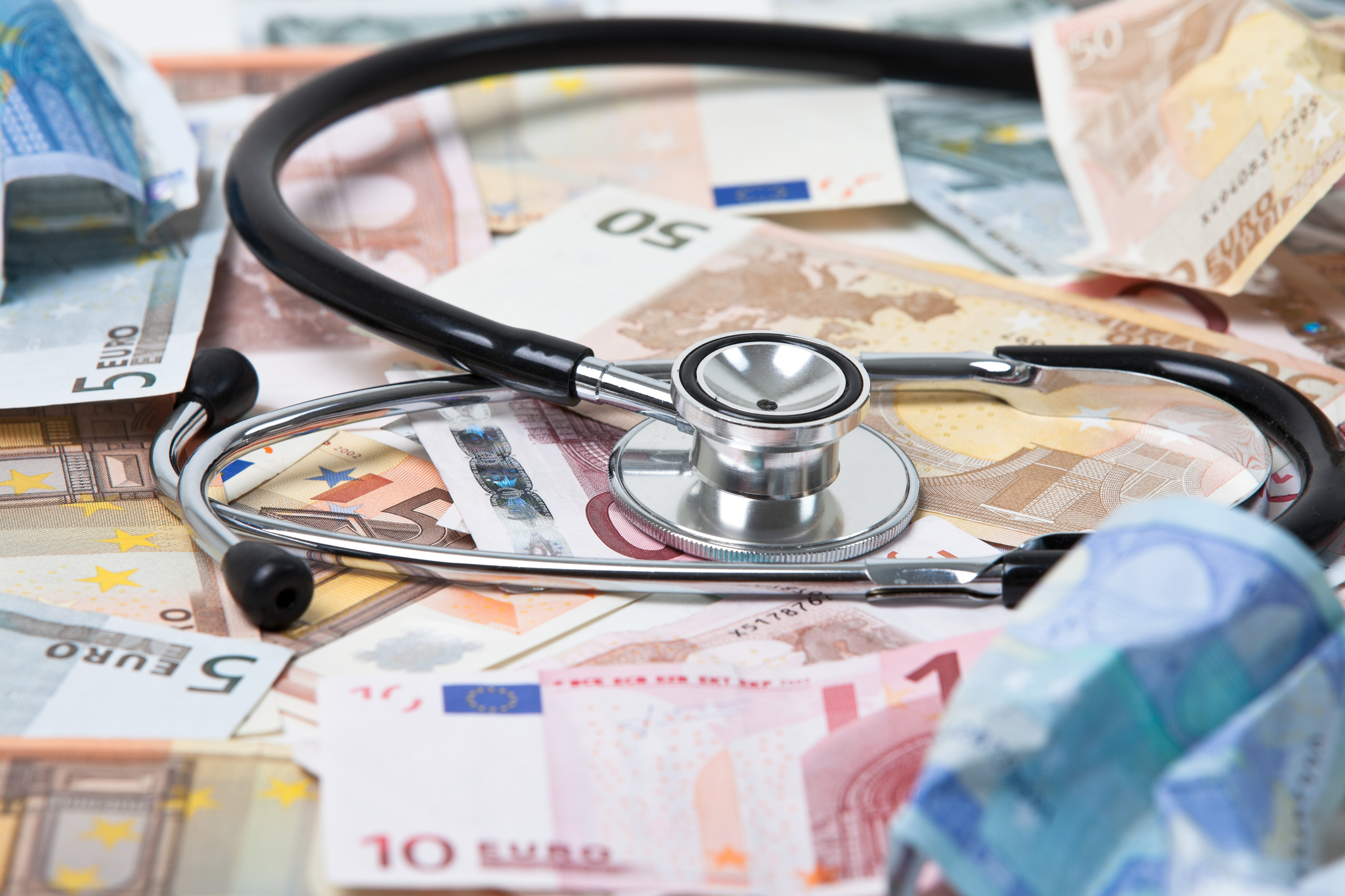Stethoskop liegt auf zahlreichen Geldscheinen der Euro-W&auml;hrung