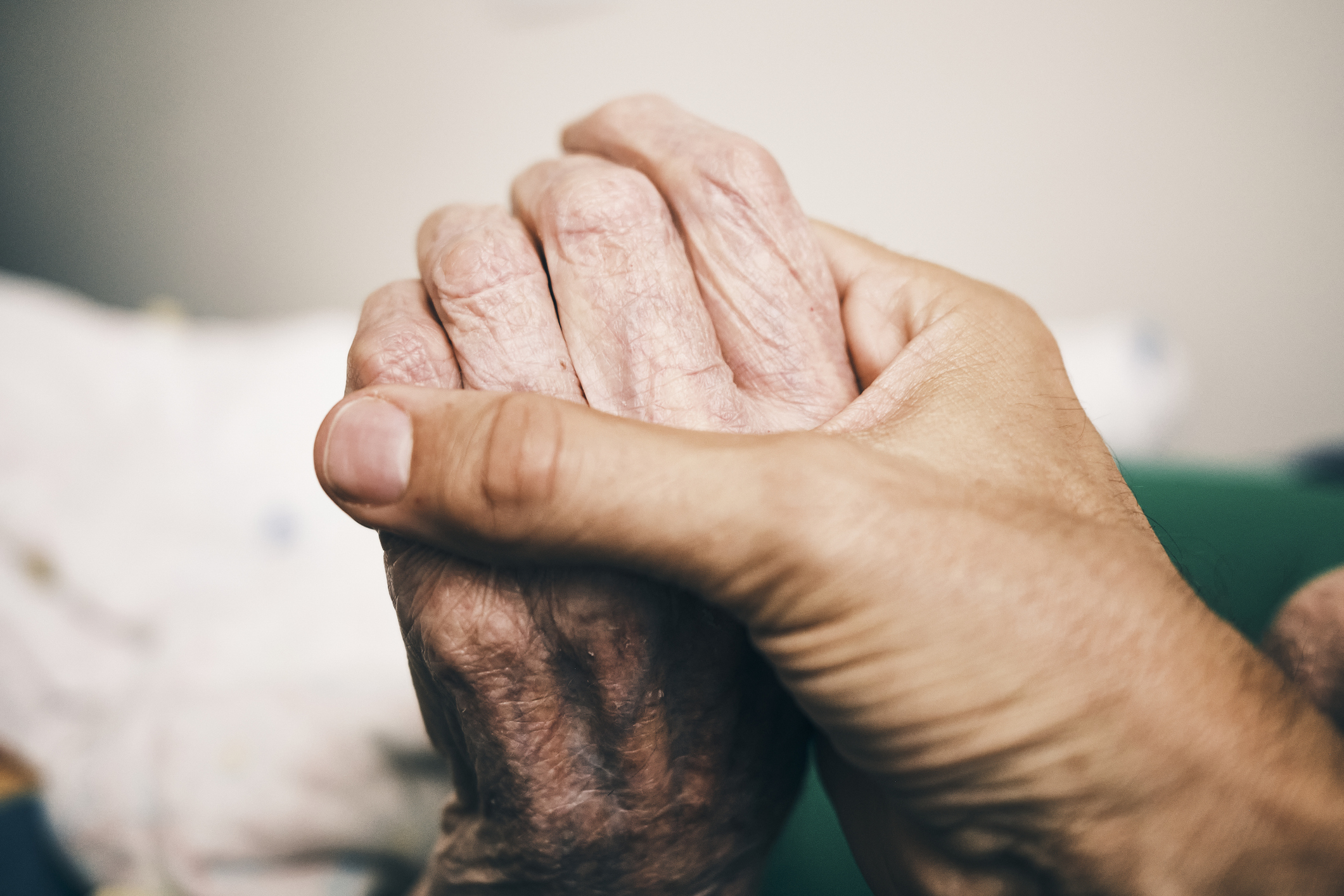 &Auml;ltere Frauenhand h&auml;lt die Hand eines &auml;lteren Mannes. 