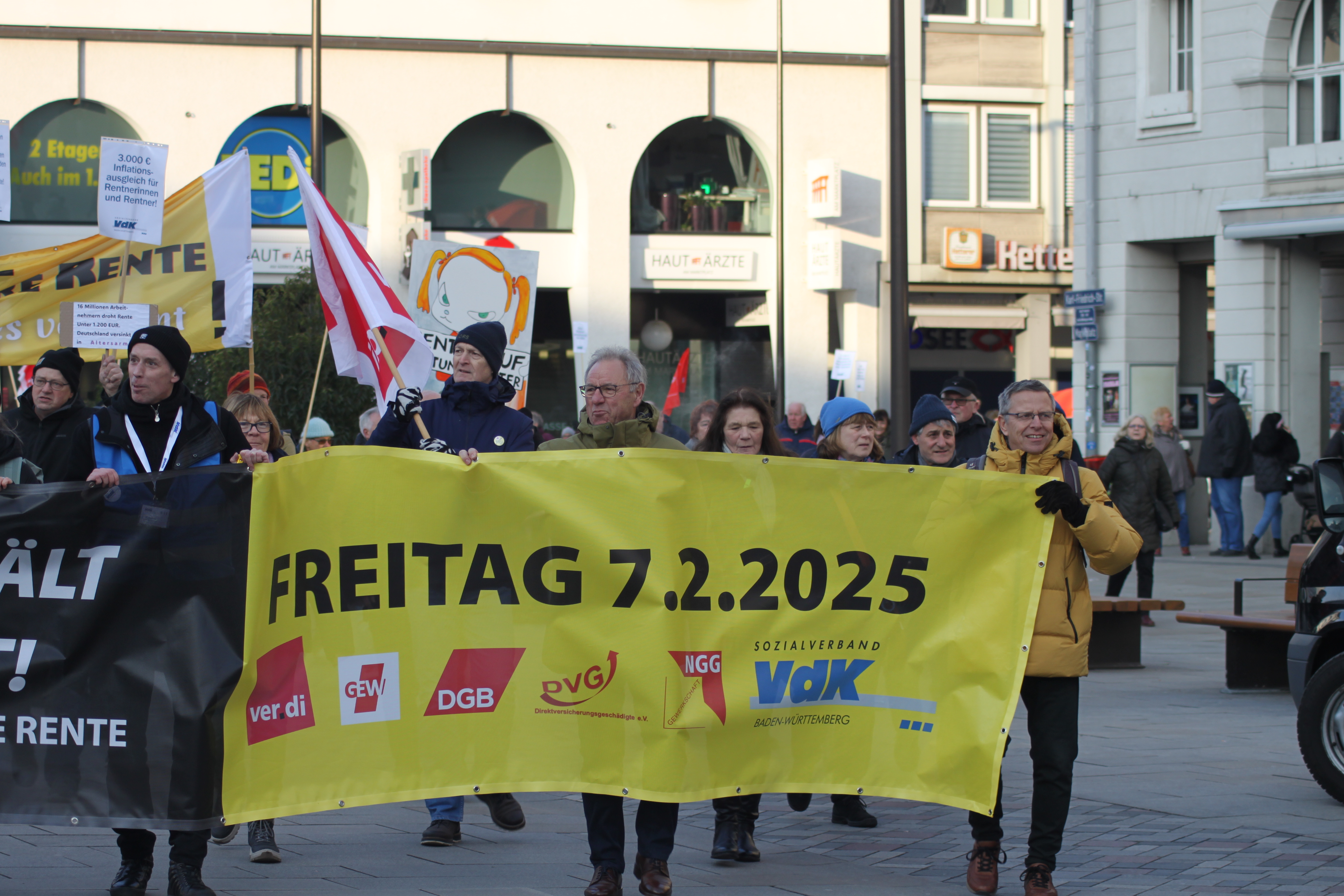 Demozug: Menschen laufen mit einem großen Transparent durch die Straßen von Karlsruhe.
