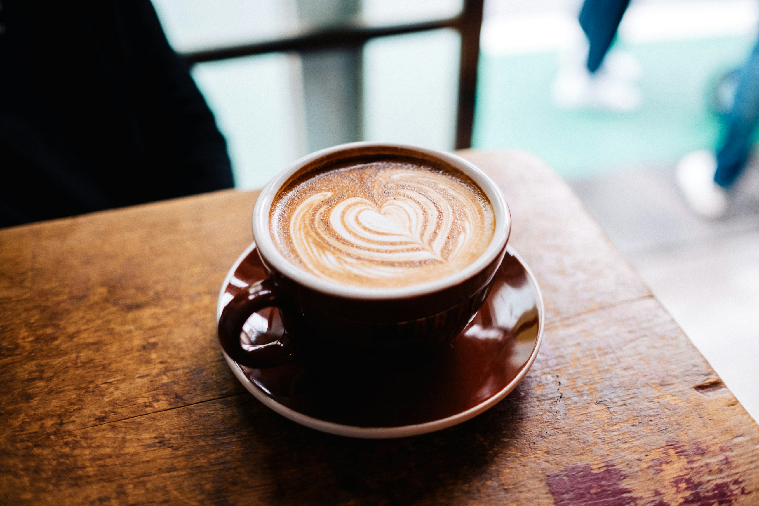 Nahaufnahme einer Tasse Cappuccino mit herzf&ouml;rmiger Latte Art.