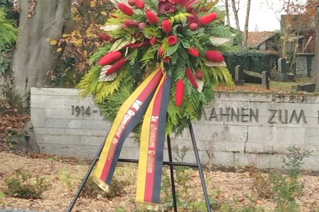 Kranzgebinde vor Ehrenmal. Keine Personen auf dem Bild.