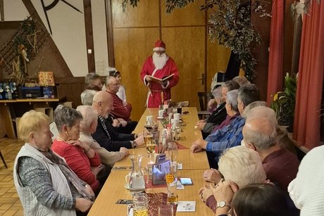 Der Nikolaus liest aus dem goldenen Buch vor, ob die Anwesenden auch das Jahr &uuml;ber flei&szlig;ig waren. Es blieb ihm nichts verborgen.
