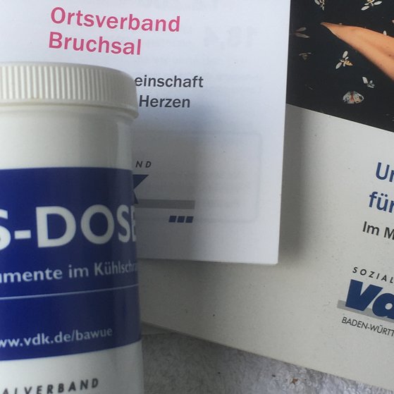 Abbildung zeigt eine SOS -Dose sowie Flyer vom VdK