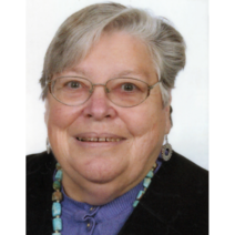 Frau mit grauen, kurzen Haaren, Brille und bunter Perlenkette.