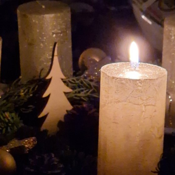 Adventskranz mit einer brennenden Kerze