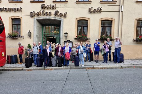 Gruppe vor Hotel winkt zum Abschied