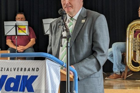 Ulrich Hildner steht am Rednerpult, vorne hängt das VdK Banner