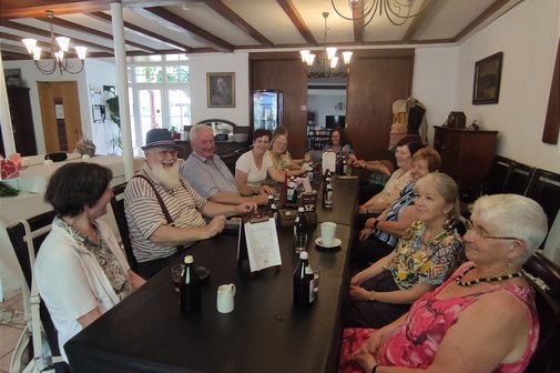 Bild zeigt Personen beim trinken und essen an Tischen im Freien