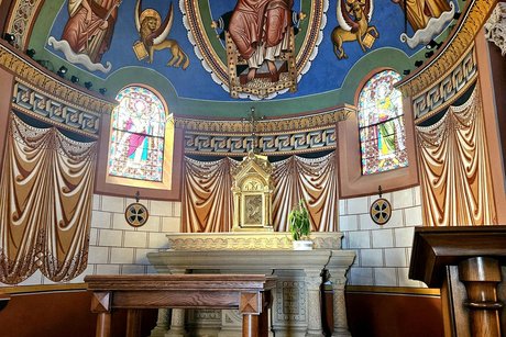 Im inneren der Kirche ein Altar unter einer Kuppel mit farbenfrohen Wand- und Deckengem&auml;lden, Jesus und deie Evangelisten in kr&auml;ftigen Farben und zwei kleine Kirchenfenster in der Wand mit Heiligenbildern.