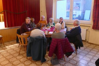 Mitglieder sitzen an einem Tisch zusammen