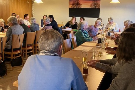 Teilnehmerrunde an mehreren Tischen