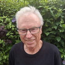 Das Foto zeigt den Revisor Siegfried Schnurr vor einer Hecke