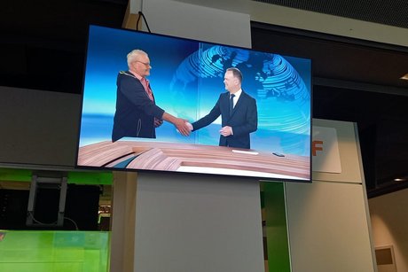 Zu sehen ein aufgeh&auml;ngter Bildschirm im ZDF-Nachrichten-Studio, zwei fernsehbekannte M&auml;nner sch&uuml;tteln H&auml;nde