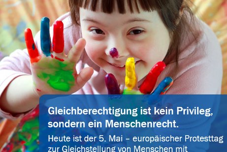 Ein Mädchen mit braunem Haar und lilanem Klecks auf der Nasenspitze hält ihre frisch verschiedenfarbig angemalten Finger und Handflächen in die Kamera, auf dem Foto die Aufschrift: Gleichberechtigung ist kein Privileg, sondern ein Menschenrecht. Heeuropäischer Protesttag zur Gleichstellung von Menschen mit Behinderungen"ute ist der 5. Mai -