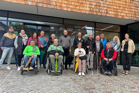Gruppenfoto der Teilnehmenden der Städtlirunde vor dem neuen MTB-Haus, vier Personen in Rollstühlen, zwei mit Blindenstöcken/Langstöcken