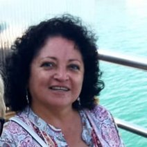 Carmen Franco de Drost hat dunkle lockige und schulterlange Haare.