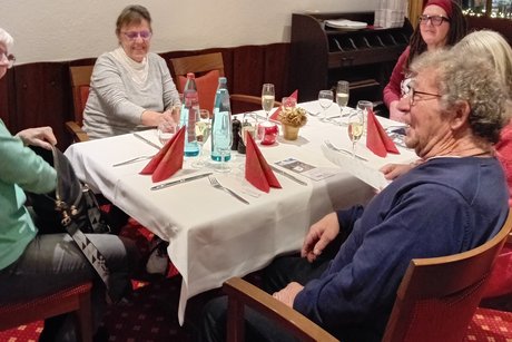 Angeregte Gespräche inklusive Besuchende der VdK-Adventsfeier um einen Tisch sitzend