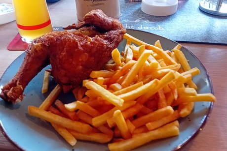 Bild zeigt einen Teller Mit Hähnchen und Pommes