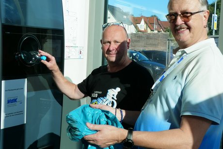 Raimar Gagesch und Thomas Hugger beim "füttern" des Pfandautomaten.