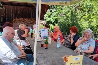 Bild zeigt die Gruppe an den Tischen im Biergarten