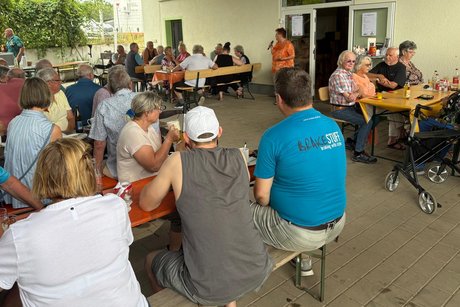 Das Bild zeigt viele Menschen sitzend an Biertischen, die Frau Berger-Bäuerle bei ihrem Vortrag über den Stadtseniorenrat Renningen zuhören.