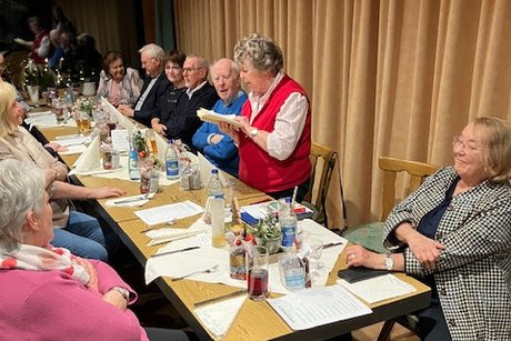 Jahresabschlussfeier VdK-OV Aichwald 2025 Ältere Menschen sitzen an einer langen Tafel und führen angeregte Gespräche.