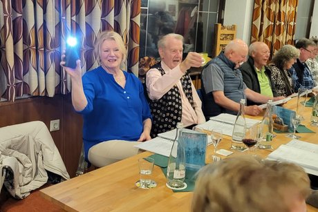 Menschen die fr&ouml;hlich Kerzen schwenken.