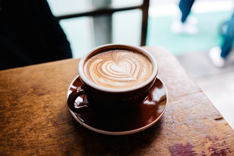 Nahaufnahme einer Tasse Cappuccino mit herzf&ouml;rmiger Latte Art.