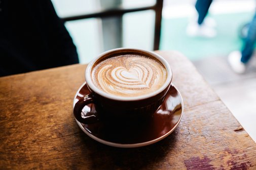 Nahaufnahme einer Tasse Cappuccino mit herzf&ouml;rmiger Latte Art.