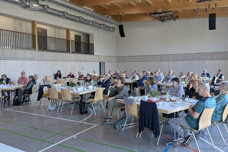 Mitglieder und G&auml;ste an sch&ouml;n dekorierten Tischen