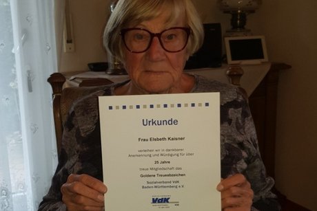 die für 25 Jahre VdK geehrte Elsbeth Kaisner mit ihrer Urkunde bei ihr zuhause
