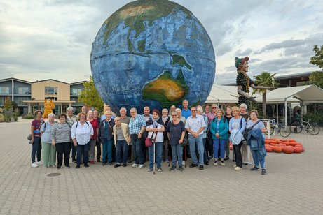 Gruppenbild im Bohrerhof vor der beeindruckenden Weltkugel