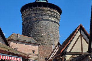 Bild zeigt ein Gruppe entlang der Nürnberger Stadtmauer und im Hintergrund der Burgturm