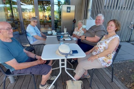 Bild zeigt eine Gruppe mit 5 Personern beim Kaffee trinken
