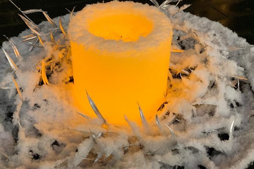 Kerze inmitten eines Schneekranzes
